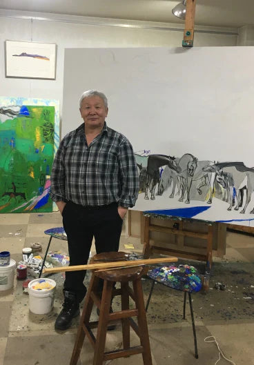 Artist, Shagdarjavin Chimeddorj, standing in an art studio with paintings and art supplies around