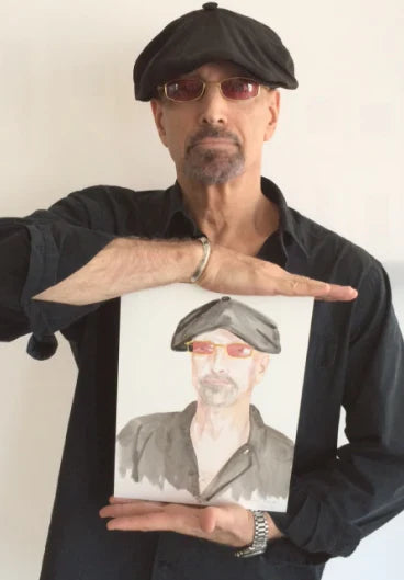 Man holding a portrait of himself with a black cap and glasses against a white background