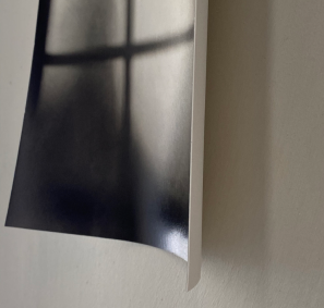 expressive almost abstract black and white photo of a window, pinned to the wall and curlying away at the bottom edges