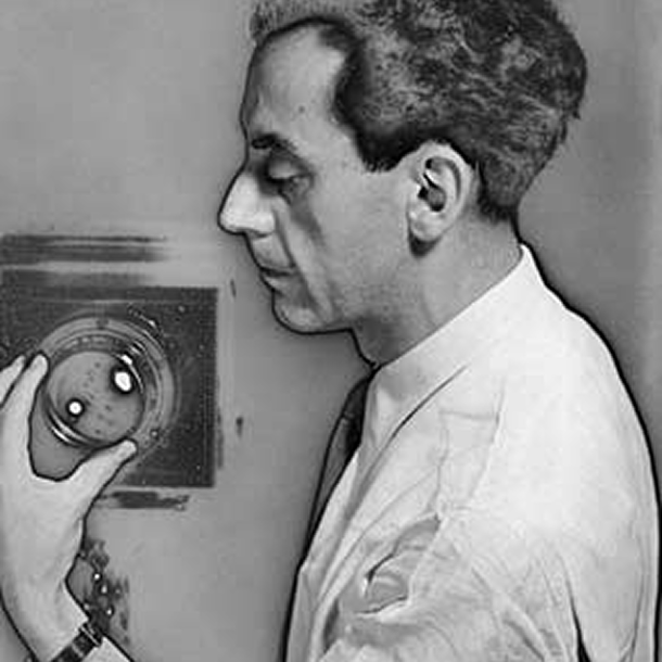a solarized profile photo of Man Ray adjusting the lens of a camer