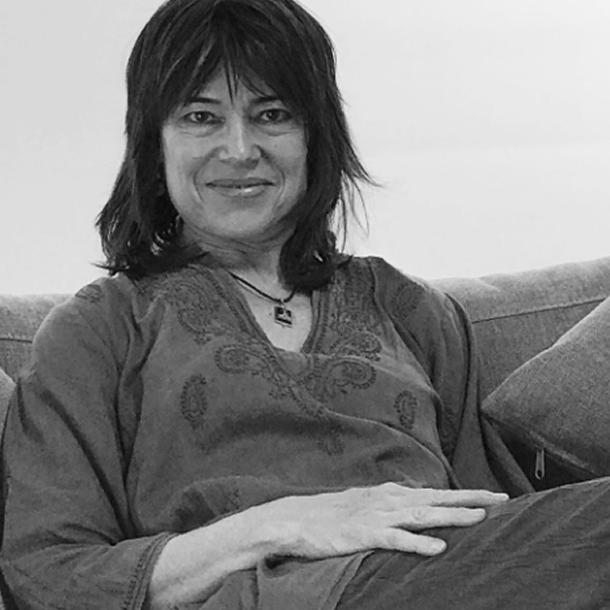 black and white photo of artist Mary Jones relaxing on her couch