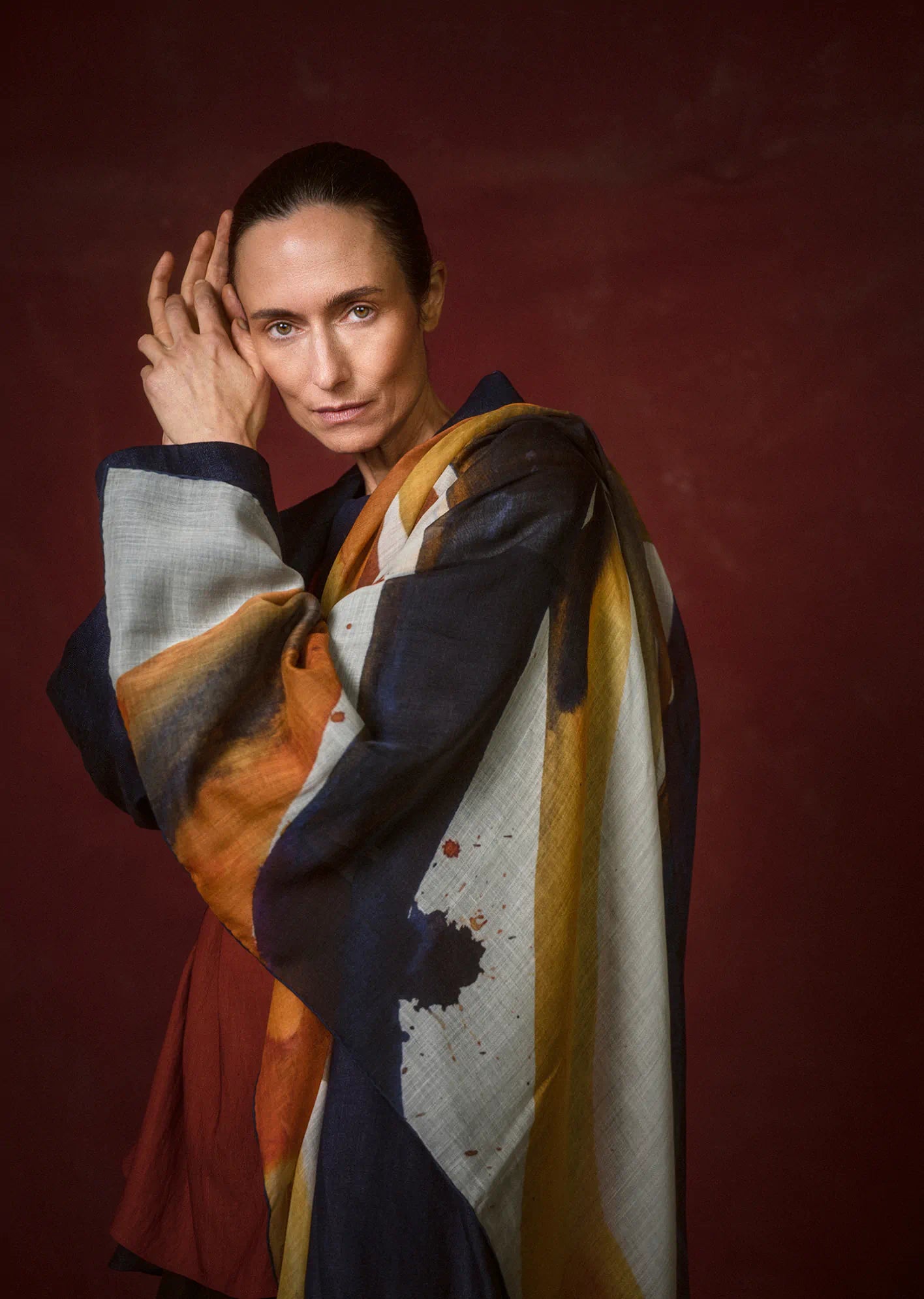 Woman wearing a colorful scarf against a red background