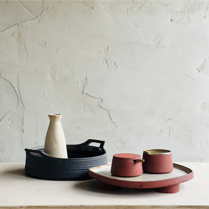 Alex Gabriel’s Ceramics sitting on a counter in front of a pale rough wall