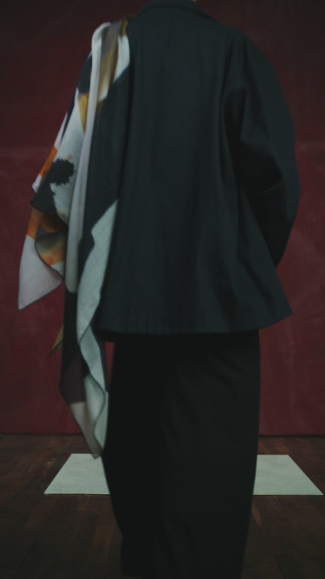 video of a Woman wearing a colorful scarf against a red background