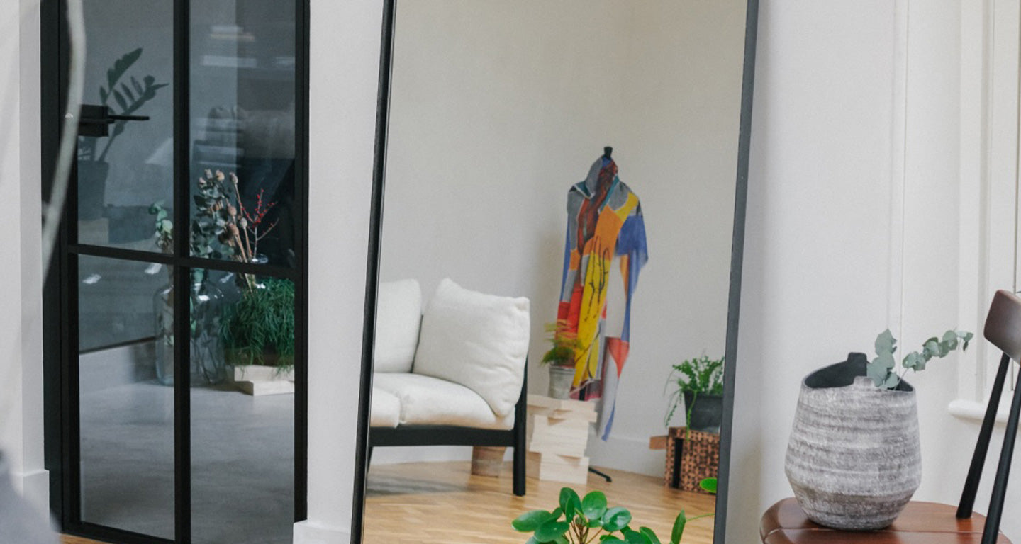 Photo of the inside of Atelier Alba Amicourm, a serene room with an art scarf draped on a dress form
